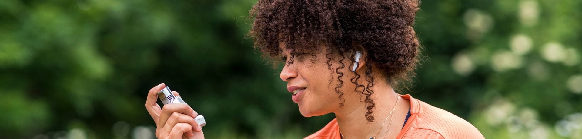 Woman holding her inhaler outside