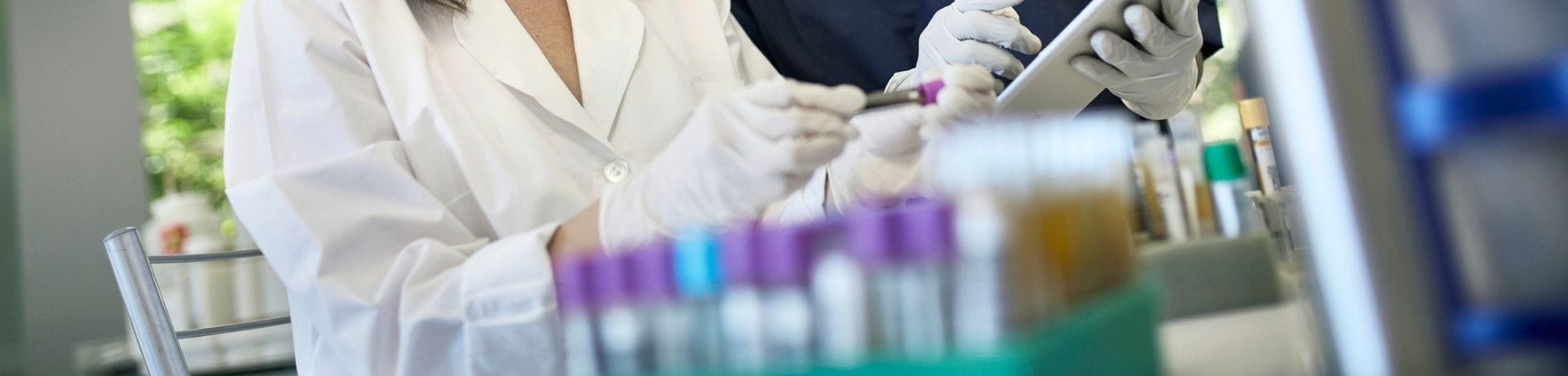People working in the lab with test tubes around them